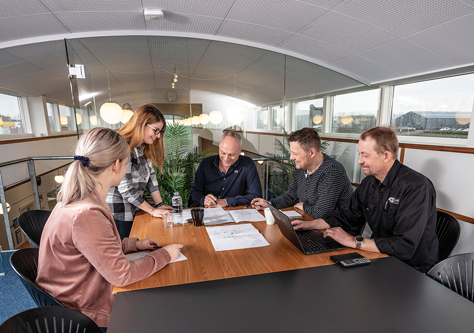 ATCOM engineering team reviewing project drawings in a meeting room